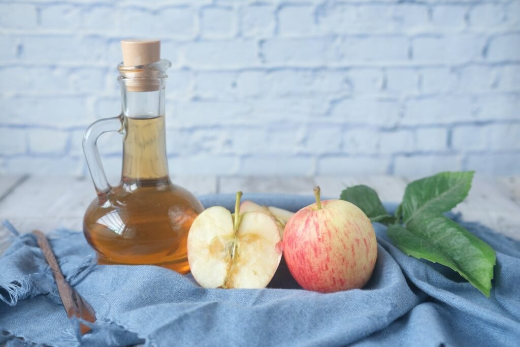 Bottle of apple cider vinegar with fresh apples