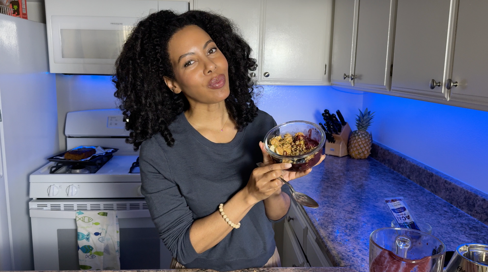 Camille tasting her homemade acai bowl in the kitchen