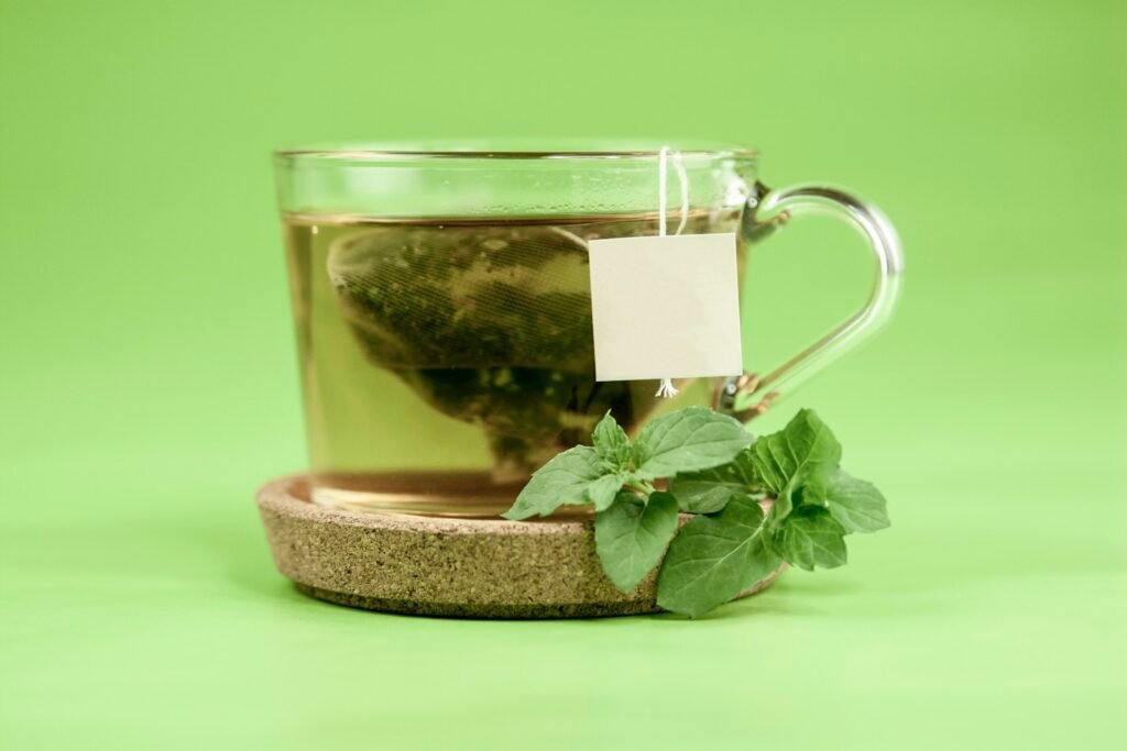 Cup of brewed green tea with fresh mint leaves